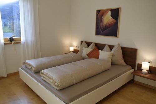 a bed sitting in a room with two lamps at NEW Amazing Apartment at Gut Wendlandt with 5 x 10 m Pool, Bolzano in Bolzano