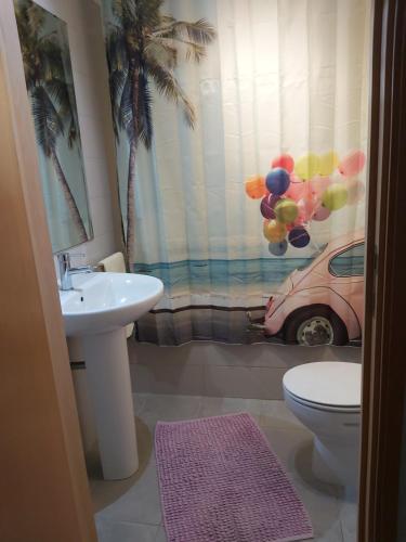 a bathroom with a sink and a toilet and a car at 106 Green North in Ribeira Grande