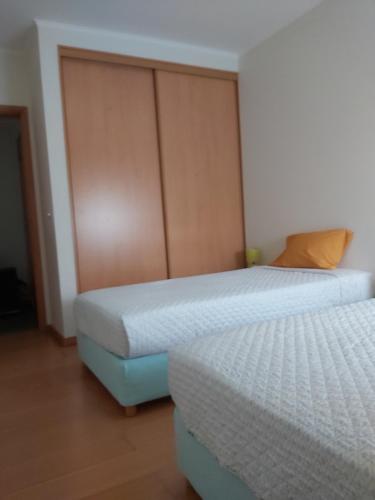 a bedroom with two beds and a wooden door at 106 Green North in Ribeira Grande