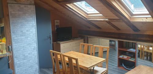 a kitchen with a wooden table and chairs and a skylight at Studio saint martin vesubie in Saint-Martin-Vésubie