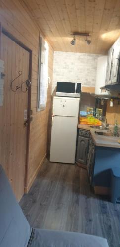 a kitchen with a white refrigerator in a room at Studio saint martin vesubie in Saint-Martin-Vésubie