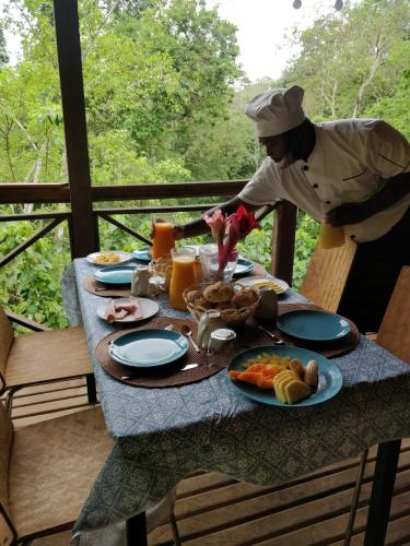 a chef preparing a table with food on it at Eden Valley Ecolodge and Farming in Madalena