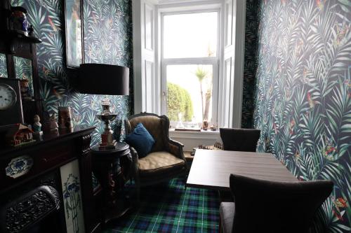 a room with a table and a chair and a window at Altavona House in Oban