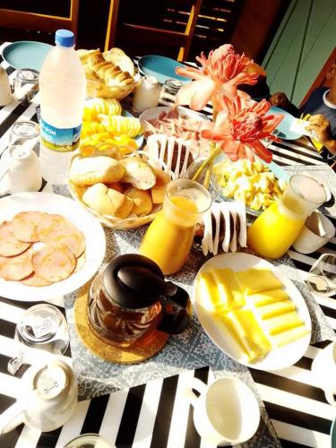 a table topped with plates of food and drinks at Eden Valley Ecolodge and Farming in Madalena