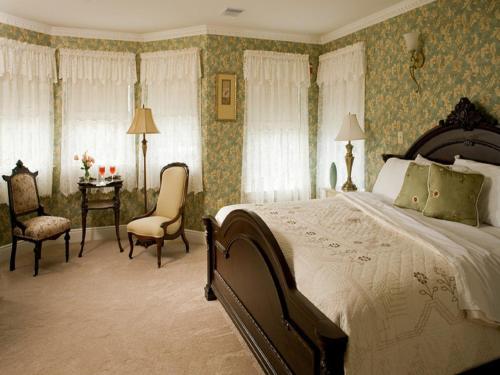 1 dormitorio con 1 cama, mesa y sillas en Wilbraham Mansion, en Cape May
