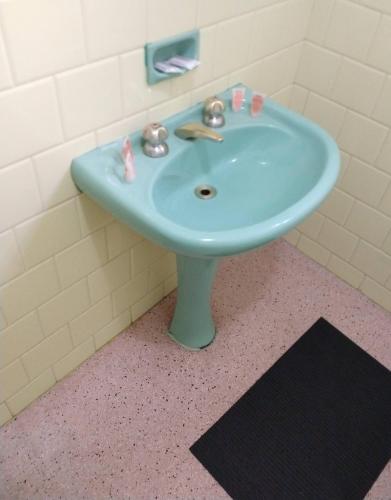 a bathroom with a blue sink in a room at Hotel Cervantes in Curitiba