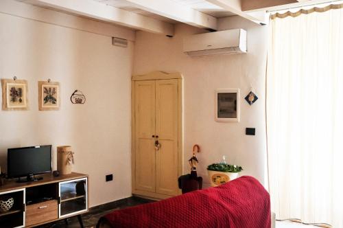 ein Wohnzimmer mit einem roten Sofa und einem TV in der Unterkunft Morgana in Casarano