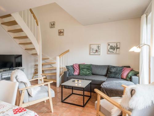 a living room with a couch and a staircase at 6 person holiday home in Blåvand in Blåvand