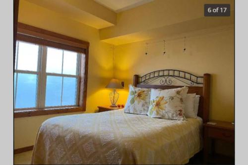 a bedroom with a bed with pillows and a window at 'The Treehouse' at Snowshoe - Village & Slope View in Snowshoe
