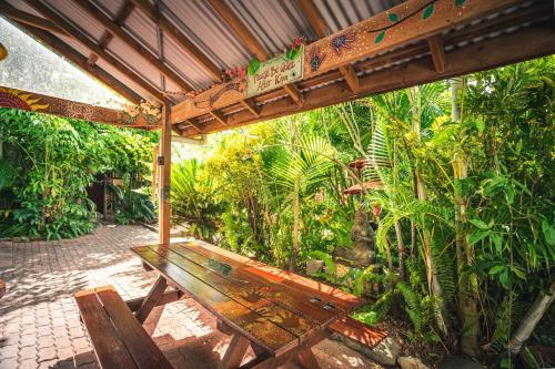
a wooden bench sitting in the middle of a lush green forest at Tropic Days Boutique Hostel in Cairns
