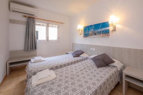 a hotel room with two beds and a window at Rosamar Holidays Apartments in Cala Ratjada