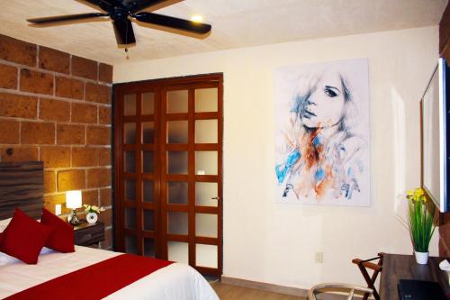 a bedroom with a bed and a painting on the wall at Hotel Boutique La Herencia in Tequisquiapan