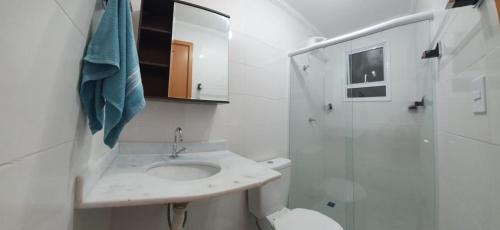 uma casa de banho com um lavatório, um WC e um chuveiro em Apartamento novo , poucos metros da praia com WI FI em Ubatuba