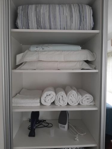 - un réfrigérateur rempli de serviettes et d'un lit dans l'établissement Apartamento aconchegante com estacionamento na 25 de março, à São Paulo