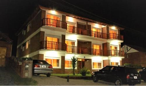 un edificio con coches aparcados frente a él por la noche en Complejo Madre Madre en Villa Gesell