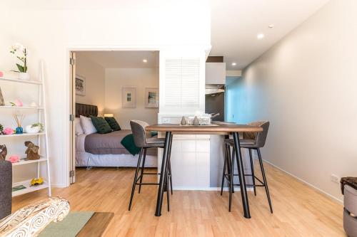 a dining room with a table and a bedroom at Oneroa Bay Villa Waiheke in Oneroa