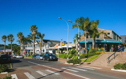 a street with cars parked on the side of the road at Oneroa Bay Villa Waiheke in Oneroa