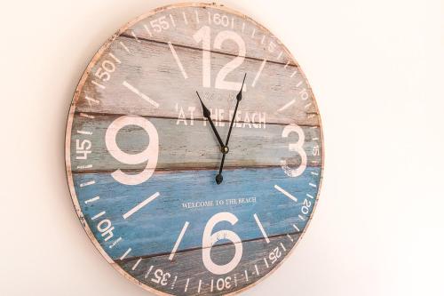 a clock hanging on a wall on a wall at Oneroa Bay Villa Waiheke in Oneroa
