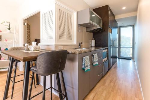 a kitchen with a counter and a table with chairs at Oneroa Bay Villa Waiheke in Oneroa