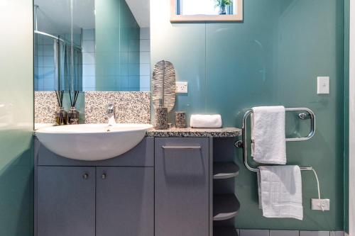 bagno con lavandino e specchio di Oneroa Bay Villa Waiheke a Oneroa