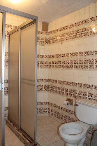 een badkamer met een toilet en een douche bij Hospedaje Primavera in Medellín