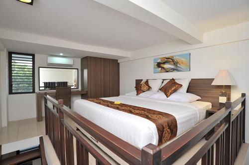a bedroom with a large bed and a desk at Ganga Hotel & Apartment in Denpasar