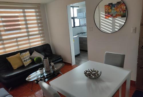 sala de estar con mesa blanca y sofá en CASA AVILA - Apartamento amoblado 1 - Villa Alsacia, en Bogotá