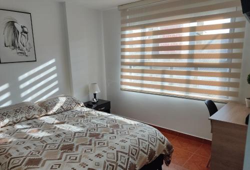 a bedroom with a bed and a window with blinds at CASA AVILA - Apartamento amoblado 1 - Villa Alsacia in Bogotá