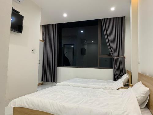 58M Motel في كاو بانغ: سريرين في غرفة نوم مع مرآة كبيرة