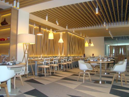 a dining room with tables and white chairs at Novotel Warszawa Centrum in Warsaw
