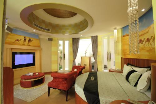 a bedroom with a large bed and a living room at Villa Bella Motel in Kaohsiung