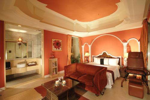 um quarto com uma cama, uma cadeira e um sofá em Villa Bella Motel em Kaohsiung