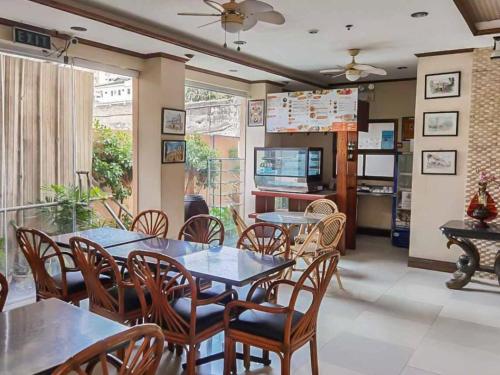 セブシティにあるRedDoorz Plus New Era Budget Hotel Mabolo former RedDoorz near Landers Superstore Cebu Cityのダイニングルーム(テーブル、椅子、テレビ付)