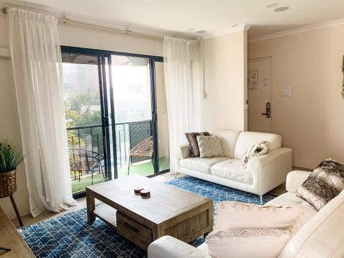 a living room with a couch and a table at Spacious Homely Apartment Close to Everything in Perth