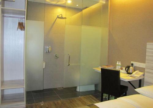 y baño con ducha, escritorio y mesa. en Hotel Austin Paradise - Taman Pulai Utama en Skudai