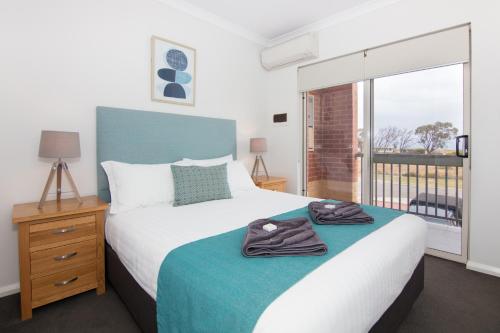 a bedroom with a bed and a large window at Jurien Bay Motel Apartments in Jurien Bay