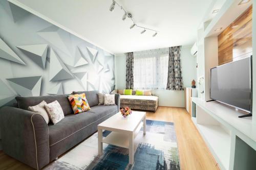 sala de estar con sofá y TV en comfort 66, en Miskolc