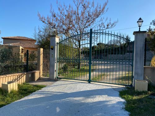 a gate to a house with a driveway at DOMAINE MAXXIM in Clermont-lʼHérault