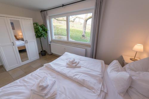 a bedroom with a bed with white sheets and a window at Gästehaus Albero in Lindau
