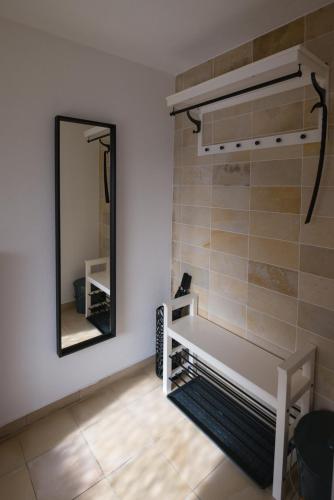 a bathroom with a mirror and a white bench at Gästehaus Albero in Lindau