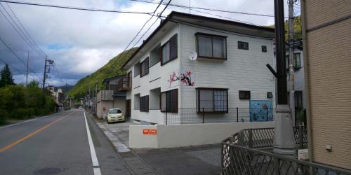 a white building on the side of a street at Akira Peak House Kinugawa in Kinugawaonsen Ohara