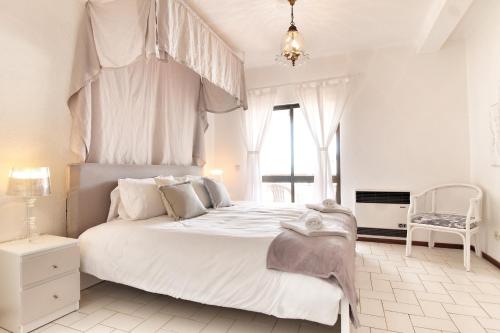 a white bedroom with a large bed with a canopy at Rustic Beach House at the Cliff T3 | C218 in Porches