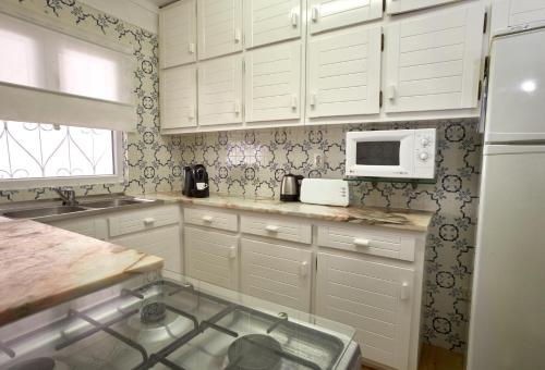 a kitchen with white cabinets and a microwave at Rustic Beach House at the Cliff T3 | C218 in Porches