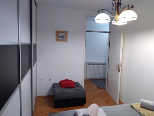 a living room with a chair and a mirror at Apartman CENTAR in Banja Luka