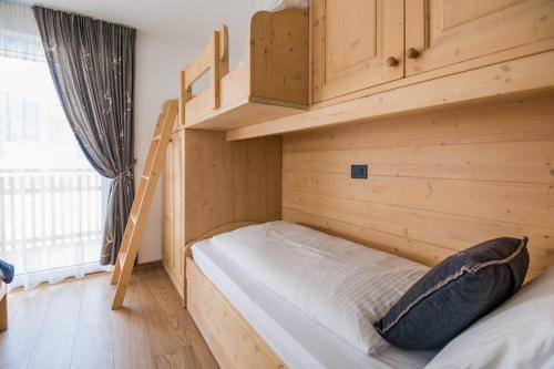 Cette petite chambre dispose de lits superposés et d'une échelle. dans l'établissement Piccola Cesa B&B, à Canazei