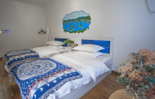 two beds in a room with white and blue at A Ben Min Su in Thousand Island Lake