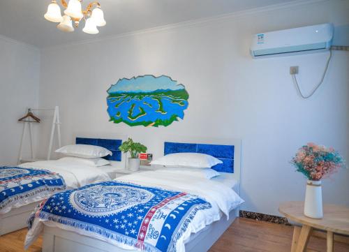 two beds in a room with blue and white sheets at A Ben Min Su in Thousand Island Lake