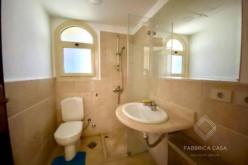 a bathroom with a sink and a toilet and a mirror at Comfy apt by Sentido Marsa Alam in Marsa Alam City
