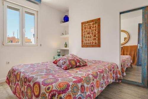 コラレホにあるCasa Aguaのベッドルーム1室(カラフルな毛布付きのベッド1台付)