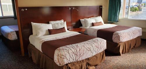 Ένα ή περισσότερα κρεβάτια σε δωμάτιο στο Olympic Inn & Suites
